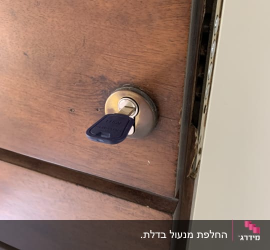 מנעול עם מפתח בדלת עץ